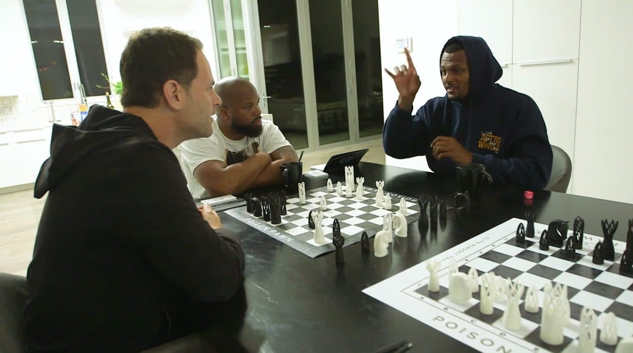 Makowsky, Watson and Avery playing chess on Poison Pawn boards at a table at night.